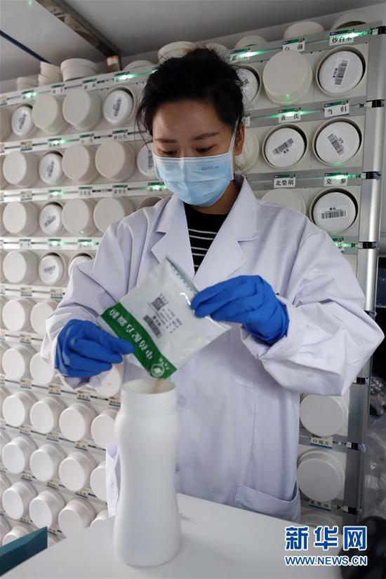 2月26日,在武汉江夏方舱医院的“流动应急智能中药房”里,工作人员吴志婷往药瓶里添加单味中药浓缩颗粒。 新华社记者 沈伯韩 摄