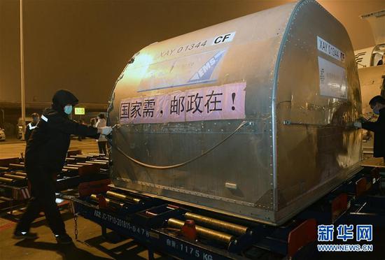 2月27日,第二批16台ECMO设备紧急运抵武汉,这是装卸员将装载ECMO设备的货仓从飞机上卸下。 新华社记者 李贺 摄